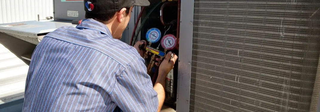 HVAC technician servicing a condenser unit in Celebration